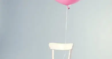 chaise blanche minimaliste avec ballon rose flottant, décoration ludique et épurée