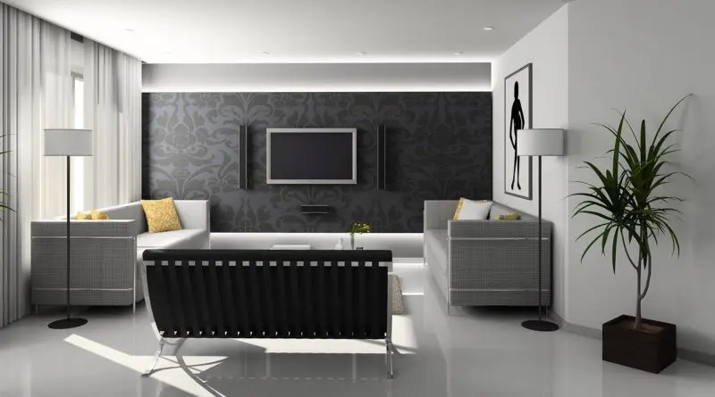 salon moderne minimaliste avec canapé noir, murs gris damassé et tv murale intégrée