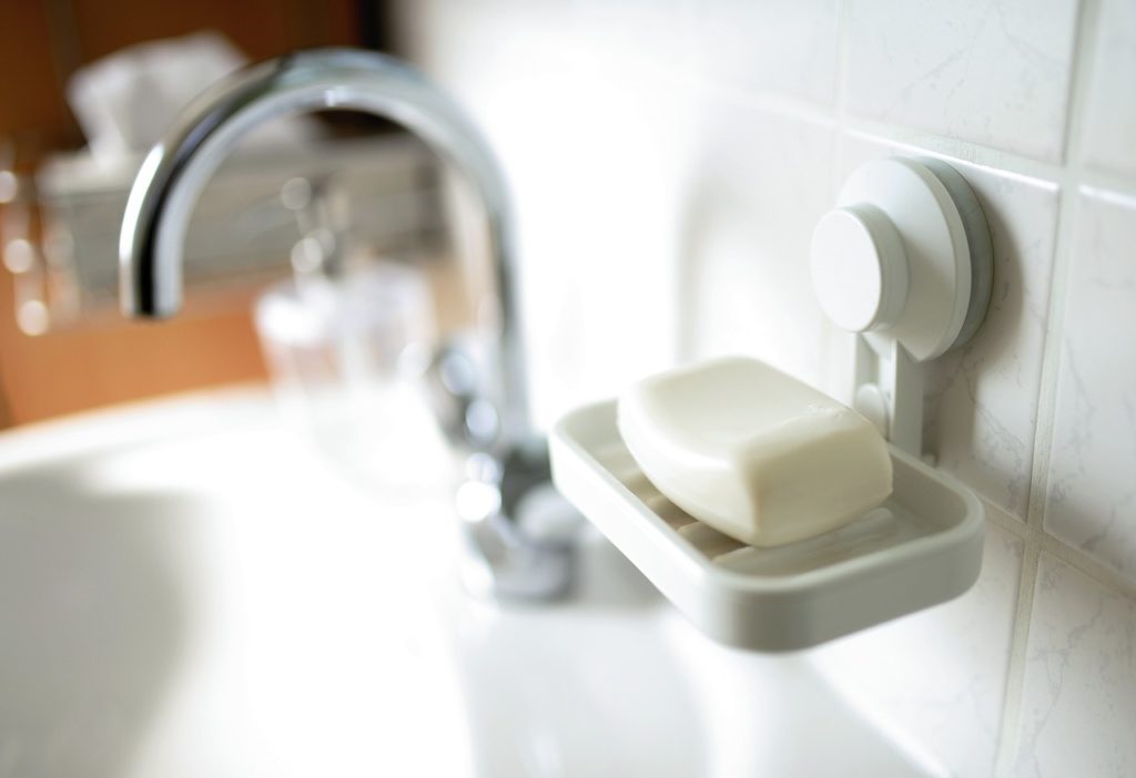 savon blanc sur porte-savon minimaliste près d'un lavabo