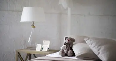 chambre minimaliste zen avec oreillers orthopédiques blancs et teddy bear sur lit