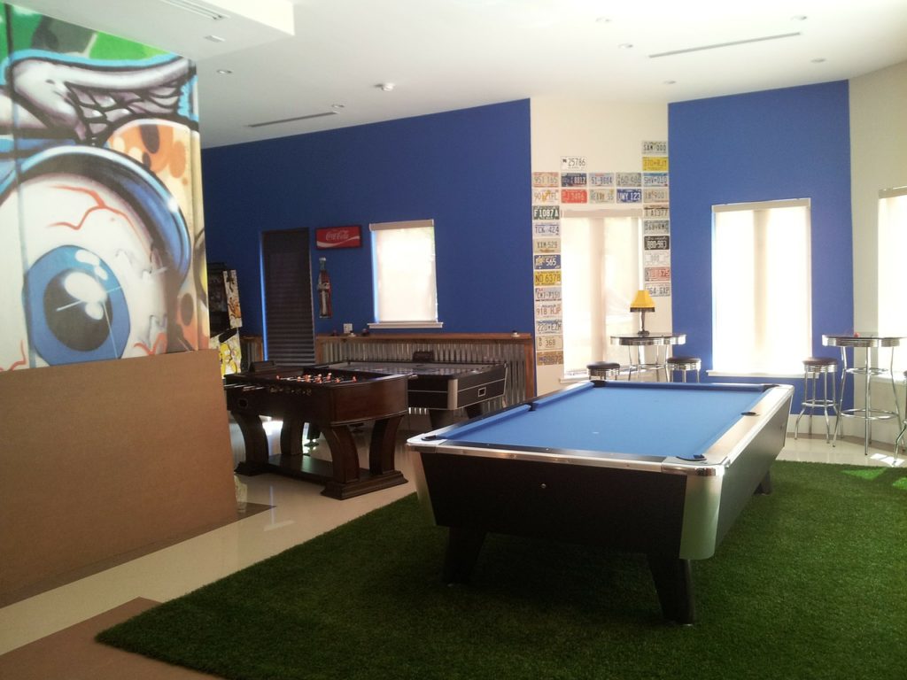 salle de jeux moderne avec billard, baby-foot et décoration murale bleue