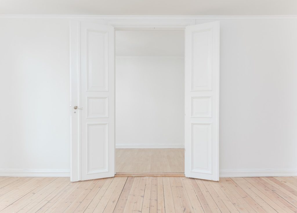 portes blanches à panneaux ouvertes sur chambre minimaliste