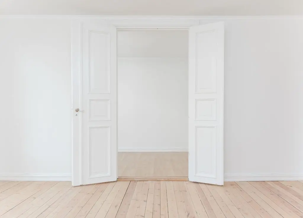 portes blanches à panneaux ouvertes sur chambre minimaliste