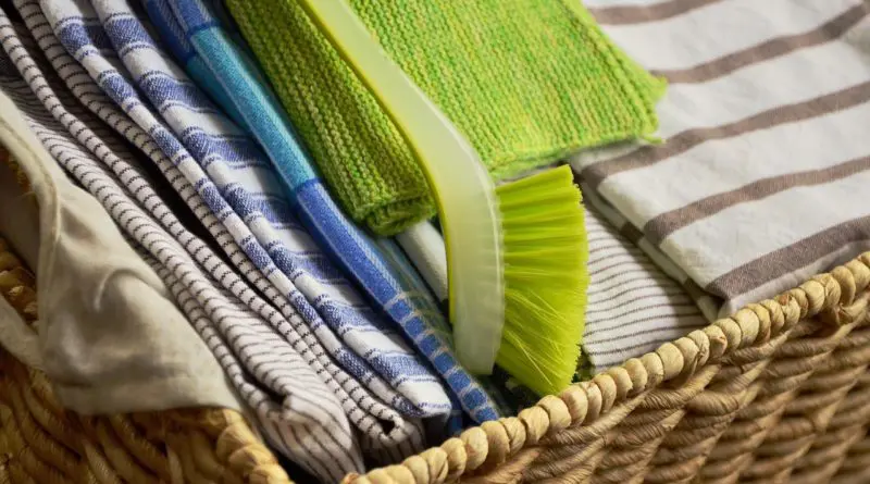 linge de cuisine plié dans un panier en osier avec brosse écologique verte