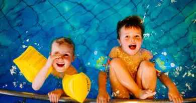 deux enfants heureux dans une piscine hors sol avec accessoires de baignade jaunes
