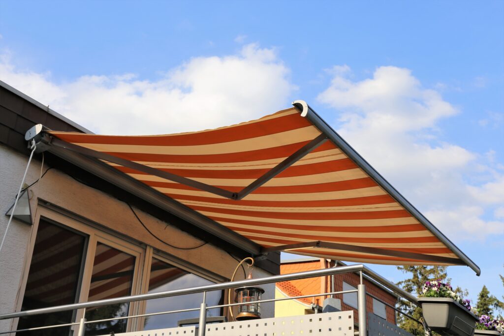 store banne rétractable rayé orange et beige déployé sur une terrasse