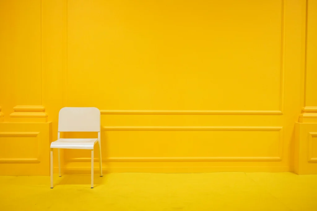 chaise blanche minimaliste dans un salon jaune vibrant et épuré