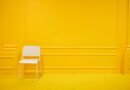 chaise blanche minimaliste dans un salon jaune vibrant et épuré