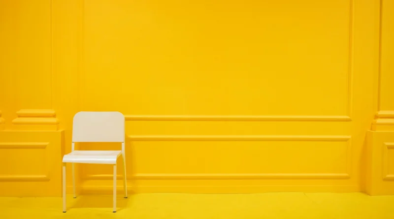 chaise blanche minimaliste dans un salon jaune vibrant et épuré