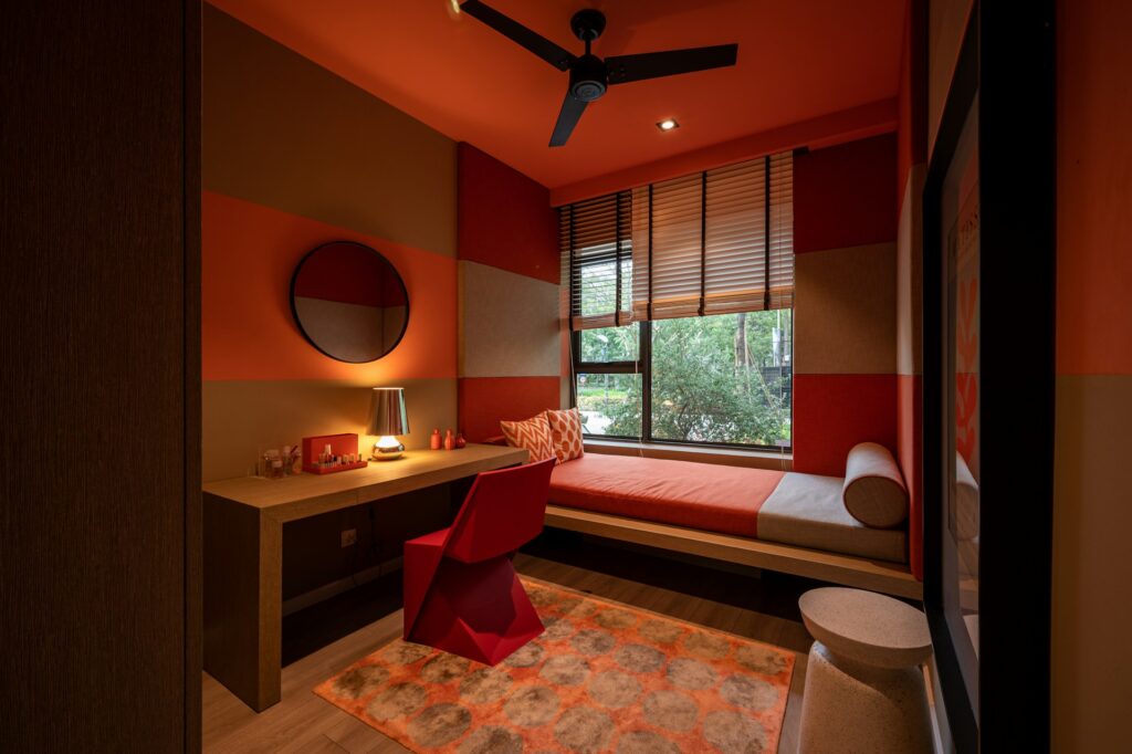chambre moderne aux murs rouge-orange avec bureau, lit et fenêtre, style minimaliste