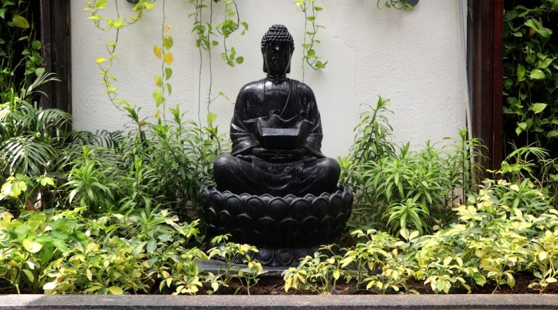 a buddha statue sitting in the middle of a garden