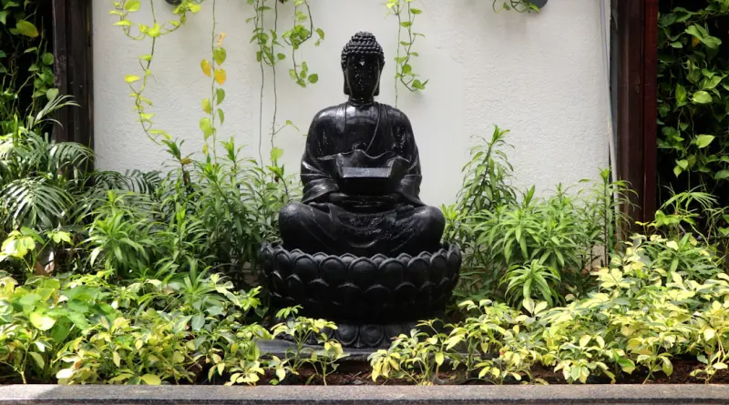 a buddha statue sitting in the middle of a garden