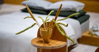 Dried grass in a wooden vase on a bedside table.