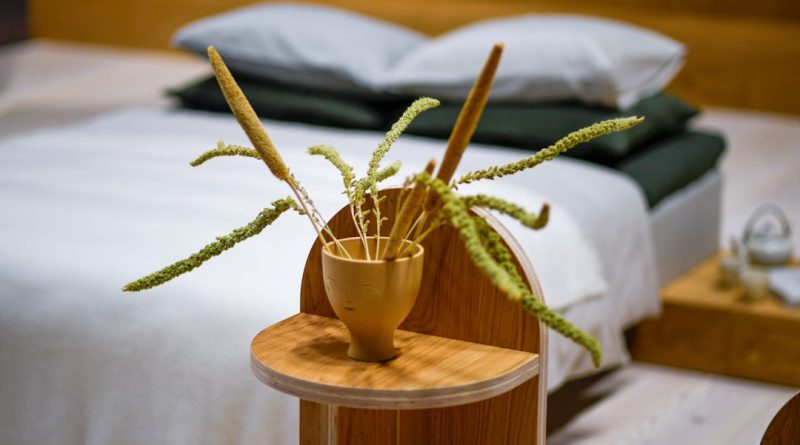 Dried grass in a wooden vase on a bedside table.