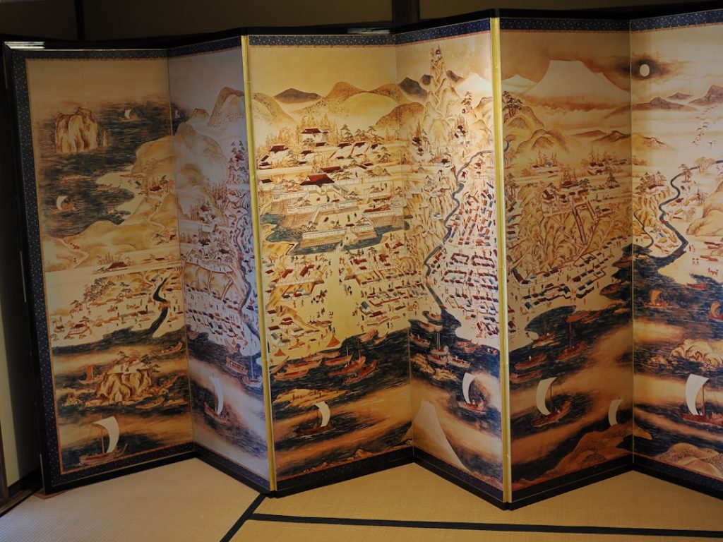 Antique map art is depicted on a folding screen.
