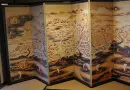 Antique map art is depicted on a folding screen.