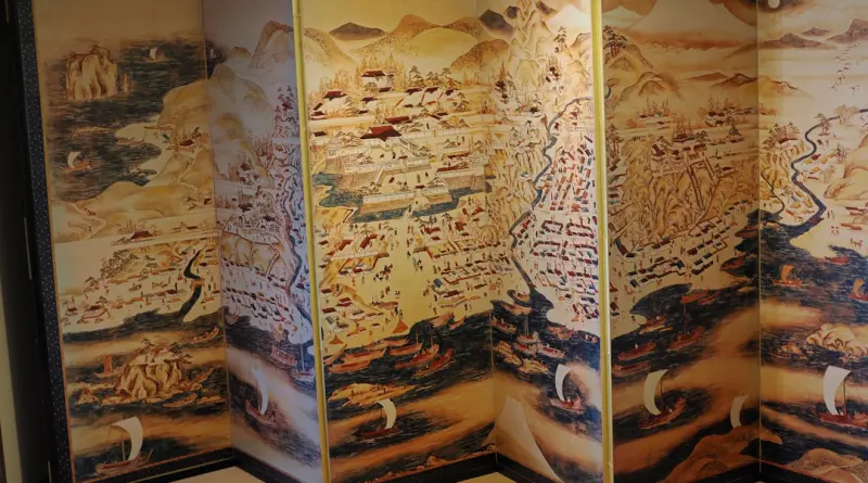 Antique map art is depicted on a folding screen.