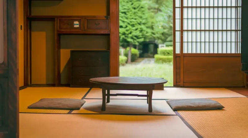 a room with a table and rugs on the floor